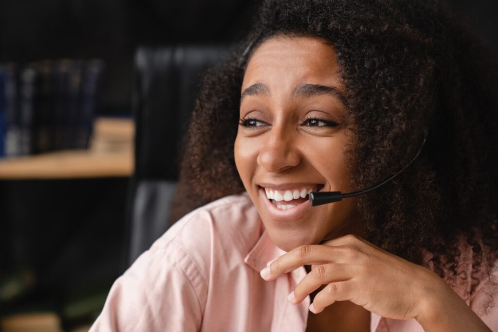 IT support customer support manager in headset using laptop, working remotely, having videocall